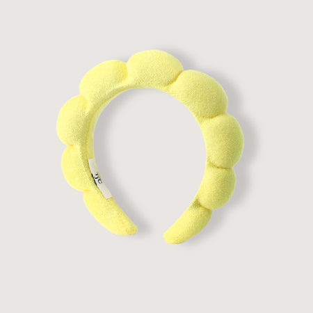 Yellow headband with a textured design on a light gray background